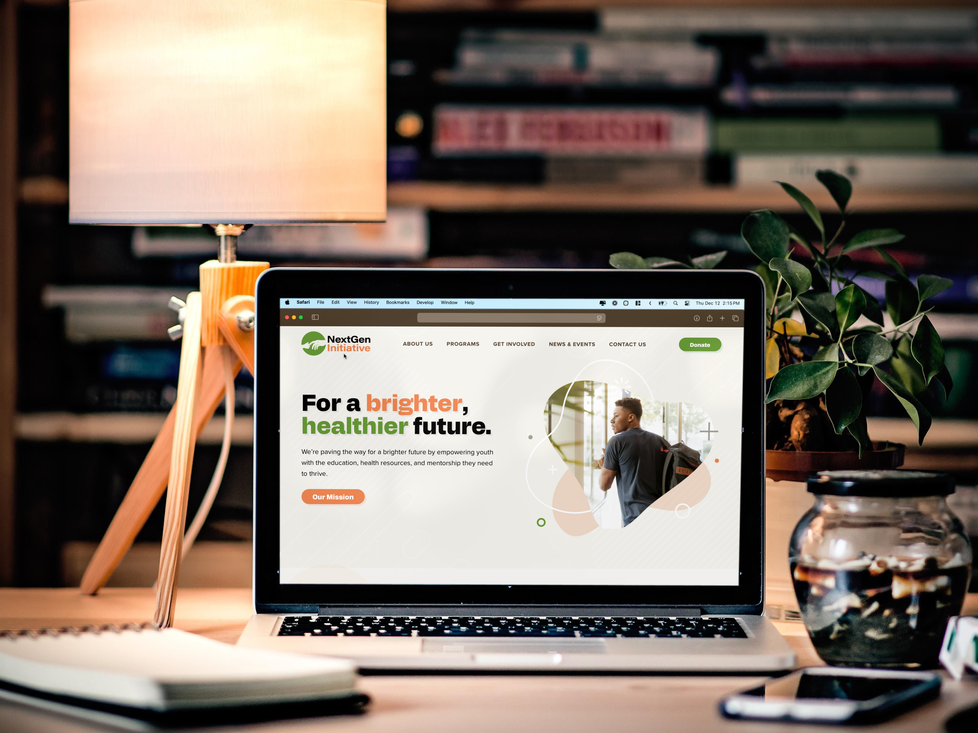 the NextGen Initiative website displayed on a laptop in a book-filled room